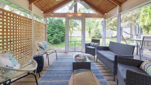 A covered patio area with wicker furniture, a ceiling fan, and string lights. - Haven Hideaway by Cottages on Wash is the perfect vacation home! (South Haven)