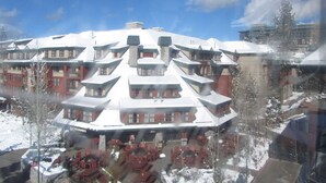 A snow-covered hotel with multiple levels and a central courtyard with outdoor seating.