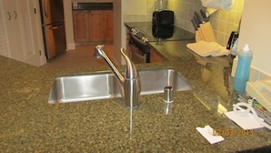 A kitchen with granite countertops, stainless steel appliances, and wooden cabinets.