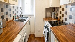 A compact kitchen with wooden countertops, a washing machine, a dishwasher, and a stove. - ☆ Central, Spacious Apartment Close to University☆ (Dundee)
