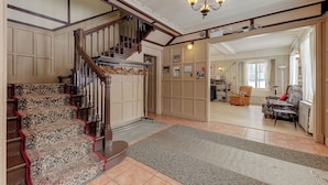 A staircase with ornate carpet and wooden railings leading to a landing. - Villa st-Léon (Saint-Gabriel-de-Valcartier)