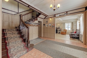 A staircase with ornate carpet and wooden railings leading to a landing. - Villa st-Léon (Saint-Gabriel-de-Valcartier)