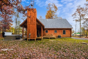 Un chalet rustique doté d’une véranda, d’un barbecue et d’un espace extérieur aménagé et abrité.