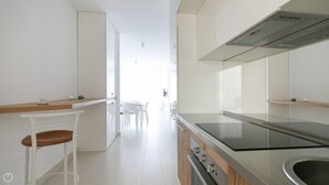 A modern kitchen with white cabinetry, a wooden countertop, and a stainless steel sink. - Rivazzurra Homes - 31 (Termoli)