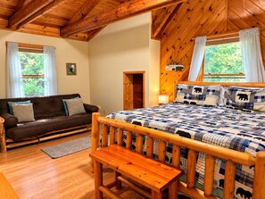 A cozy room with a wooden bed, a brown sofa, and a bench.