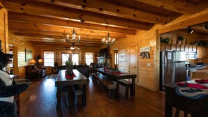 Una cabaña de madera espaciosa con un amplio comedor, cocina y una sala de estar acogedora.