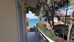 Un balcon avec vue sur la mer, un sol carrelé et une balustrade.