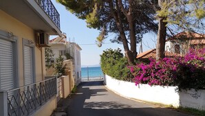 Une rue étroite bordée d’immeubles dotés de balcons, qui mène à un point de vue sur la mer.