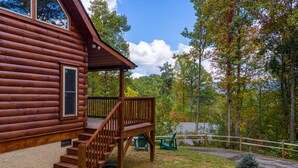 A wooden cabin with a porch and steps leading to a deck. - Smoky Retreat (Gatlinburg)