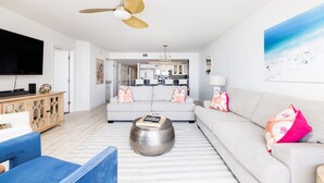 Un salon moderne avec un canapé, une table basse et un téléviseur.
