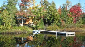 A cabin by a lake with a dock and a boat. - Welcome to the Chalets du Lac Grenier (CHERTSEY)