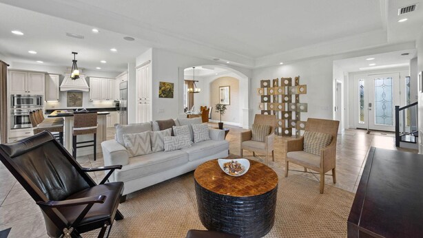 A spacious living area with a sofa, chairs, a coffee table, and a kitchen in the background. - Paradise Lovers Dream Coronas Amarilla (Siesta Key)