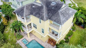 A multi-story house with a swimming pool, balconies, and a well-maintained garden. - Paradise Lovers Dream Coronas Amarilla (Siesta Key)