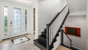 A modern staircase with black railings and a handrail, leading to an upper floor. - Paradise Lovers Dream Coronas Amarilla (Siesta Key)