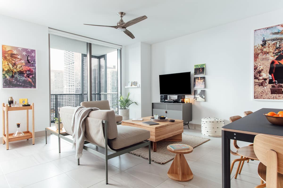 A modern living room with a sofa, coffee table, and dining area.