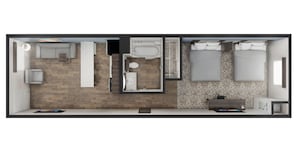 Habitación de hotel moderna con suelo de madera, cama grande, baño independiente, una pequeña zona de estar y un escritorio.
