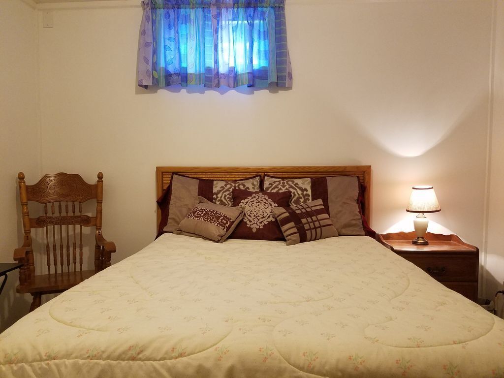 Bedroom with full bed, high back chair, bureau, 32 inch smart tv and netflix.
