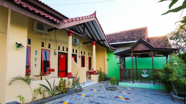 A building with a yellow facade, red doors, and a green roof. - El Shaday Family Residence (Banyuwangi)