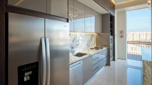A modern kitchen with a built-in refrigerator, a water dispenser, and a marble countertop. - Ritzy Pier 57 Penthouse  Ocean Views Romantic Zone (Puerto Vallarta)