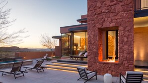 A modern outdoor patio with lounge chairs, a fire feature, and a view of the landscape. - Luxury Service 3 Kings and Bunks & PRIVATE Pool - Sleeps 12 -  Daily HK (Ivins)