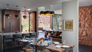 A modern kitchen with a large island, bar seating, and a stone wall. - Luxury Service 3 Kings and Bunks & PRIVATE Pool - Sleeps 12 -  Daily HK (Ivins)