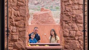 A framed photograph of a family in a desert landscape, set against a stone wall. - Luxury Service 3 Kings and Bunks & PRIVATE Pool - Sleeps 12 -  Daily HK (Ivins)
