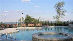 Une piscine avec des chaises longues et un jacuzzi.