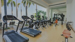 Een sportschool met loopbanden, hometrainers en krachtapparaten.