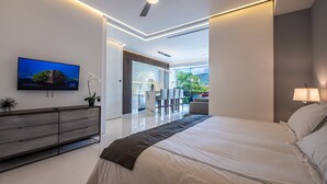 Een moderne slaapkamer met een groot bed, een televisie, een bureau en uitzicht op de omgeving.