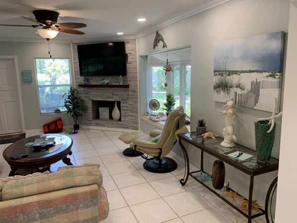 Relax in style with a large flat-screen TV, comfortable armchair, and cozy fireplace.