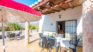 Relax in style on this patio, complete with a table for two and comfortable seating.