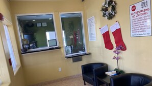 A reception area with a desk, two chairs, a Christmas stocking, and a caution sign. - Redwood Suites (Houston)