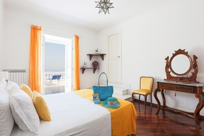 Een hotelkamer met een bed, een bureau, een stoel en uitzicht op de omgeving.