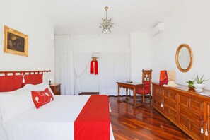 Ein Hotelzimmer mit einem Bett, einem Holzschrank, einem Schreibtisch und einem Stuhl.