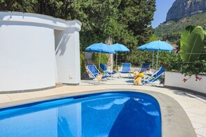 Una piscina al aire libre, tumbonas