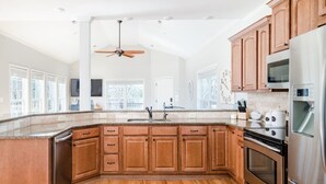 Una cocina moderna con armarios de madera, electrodomésticos de acero inoxidable y encimera de granito.