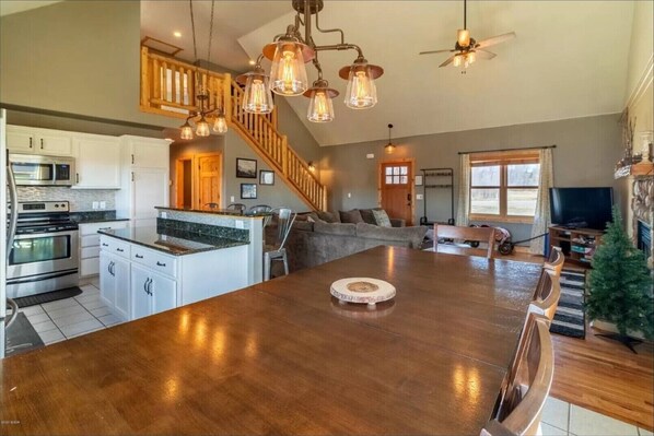 Enjoy meals in the kitchen with a large island and dining area, featuring a wooden table and chairs.