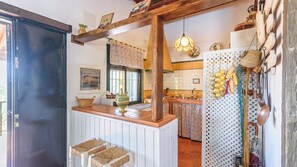 A kitchen with a wooden counter, a hanging light fixture, and a tiled backsplash.