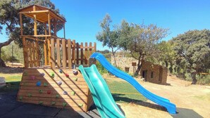 Une aire de jeux avec un mur d’escalade et un toboggan.