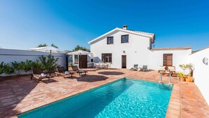 Una villa moderna con piscina, area salotto esterna e patio.