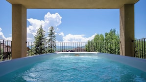 Un jacuzzi con vistas despejadas a montañas y árboles al fondo.