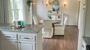A kitchen with a central island, white cabinetry, and a wooden floor. - Prime Location Masters Rental - Only 2.2 miles from course in Augusta, GA! (Augusta)