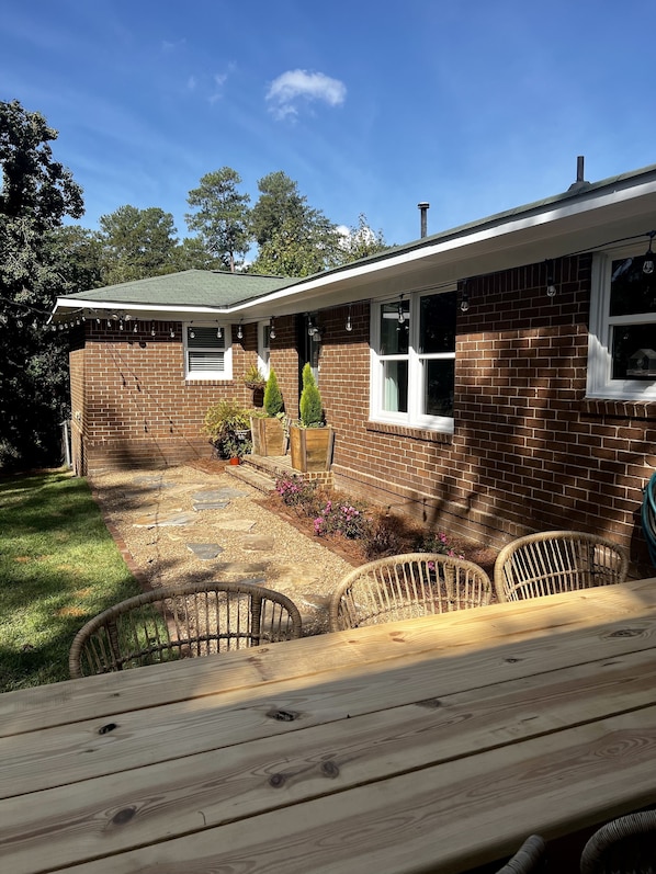A brick house with a patio, outdoor seating, and a small garden. - Prime Location Masters Rental - Only 2.2 miles from course in Augusta, GA! (Augusta)