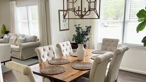 A dining area with a wooden table, six chairs, and a hanging light fixture. - Prime Location Masters Rental - Only 2.2 miles from course in Augusta, GA! (Augusta)