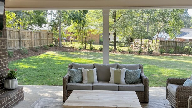 A covered patio with wicker furniture, a ceiling fan, and a view of a grassy yard. - Prime Location Masters Rental - Only 2.2 miles from course in Augusta, GA! (Augusta)