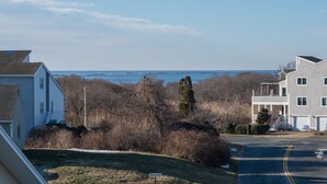 Ein Wohngebiet mit Häusern, einer Straße und Blick auf das Meer.