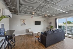 A modern interior with a dining area, a sofa, and a large window.