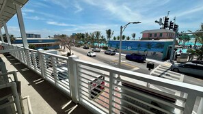 A bridge with a white railing, a road with cars, and a building with a mural in the background.