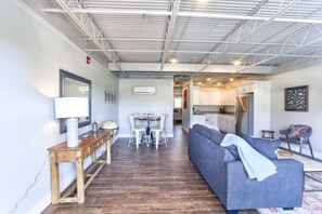 Un interior moderno con una zona de comedor, un sofá y una cocina al fondo.