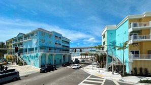 Un hotel de varios pisos con balcones, una pasarela peatonal y vistas a la calle.
